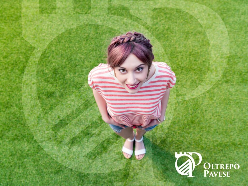 Ragazza su prato con Logo del Portale dell'Oltrepò Pavese